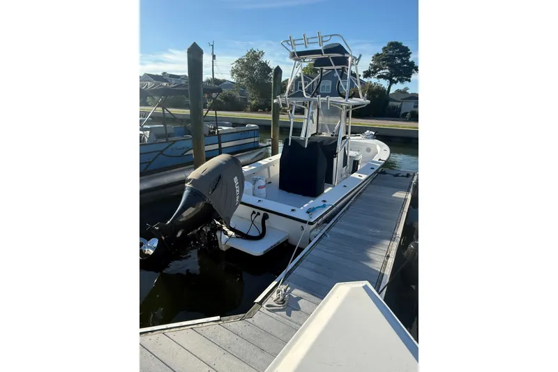 Slide: The Image of 2015 C-Hawk 25 Center Console boat docked with Suzuki outboard motor. - 2
