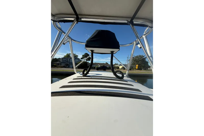 Slide: The Image of 2015 C-Hawk 25 Center Console boat with T-top, docked near waterfront homes. - 13