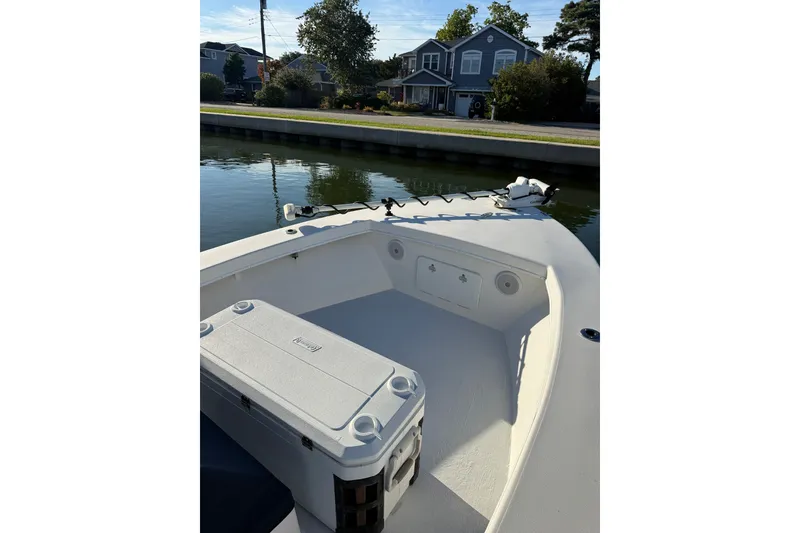 Slide: The Image of 2015 C-Hawk 25 Center Console boat on calm water near a residential area. - 3