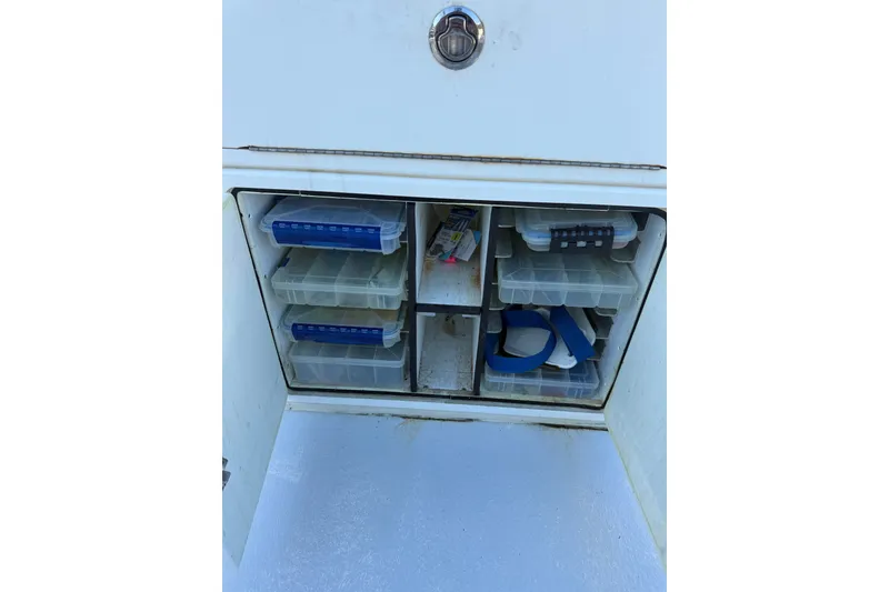 Slide: The Image of Storage compartment with organized tackle boxes on a 2015 C-Hawk 25 Center Console boat. - 20