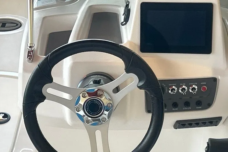 Slide: The Image of Steering wheel and dashboard of 2027 Tahoe T18 boat, featuring modern controls and display. - 9