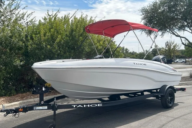 The Image of 2027 Tahoe T18 boat with red canopy on trailer, parked outdoors. - 0