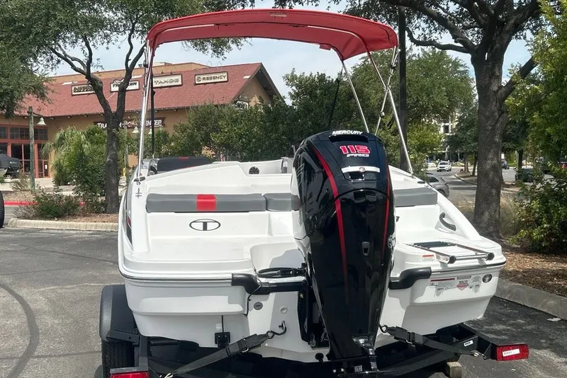Slide: The Image of 2027 Tahoe T18 boat with Mercury 115 engine, parked outdoors under trees. - 3