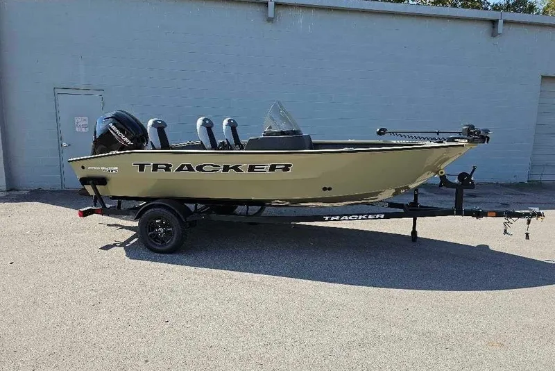 The Image of 2027 Tracker Pro Guide V-16 SC boat on trailer, parked outdoors. - 0