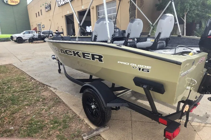 Slide: The Image of 2027 Tracker Pro Guide V-16 SC boat on trailer, parked outside a building. - 23