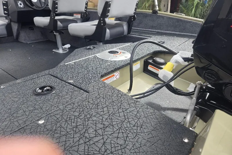 Slide: The Image of Interior of 2027 Tracker Pro Guide V-16 SC boat, featuring seating and storage compartments. - 24