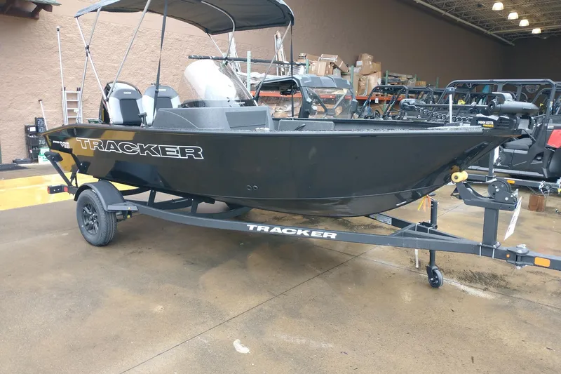 The Image of 2027 Tracker Pro Guide V-16 SC boat on trailer in showroom setting. - 0