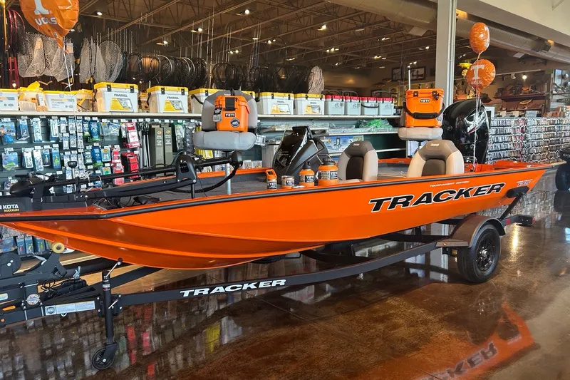 The Image of 2027 Tracker Pro Team 175 boat in showroom, vibrant orange color, equipped with Yeti gear. - 0