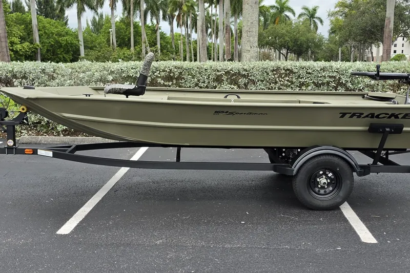 The Image of 2027 Tracker Grizzly 1654 T Sportsman boat on trailer in parking lot. - 0