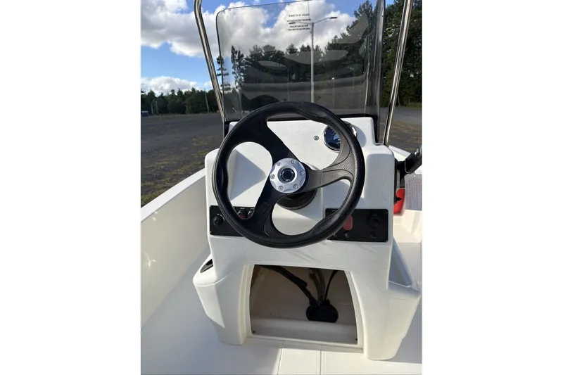 Slide: The Image of Steering console of 2026 Mako Pro Skiff 13 CC boat under clear sky. - 8