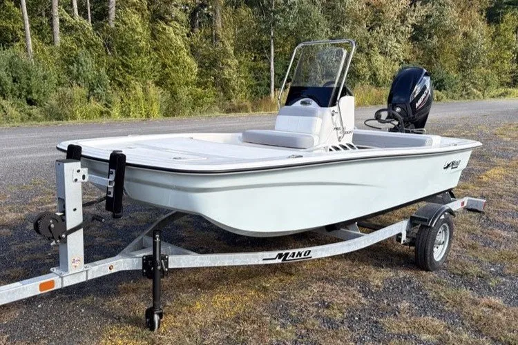 Slide: The Image of 2026 Mako Pro Skiff 13 CC boat on trailer, parked outdoors. - 1