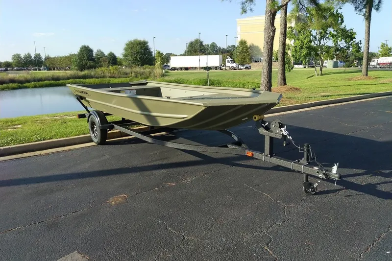 Slide: The Image of 2027 Tracker Grizzly 1754 Utility boat on trailer, parked near a pond. - 28