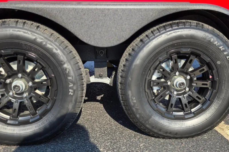 Slide: The Image of Dual wheels of a 2027 Tracker Savage 215 trailer on asphalt. - 26
