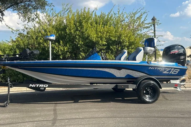 Slide: The Image of 2027 Nitro Z18 XL Pro boat on trailer, blue and silver design, parked outdoors. - 4
