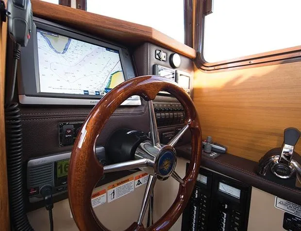 Slide: The Image of Manufacturer Provided Image: 2017 Ranger Tugs R-27 helm with GPS navigation, wooden steering wheel, and control panel. - 27