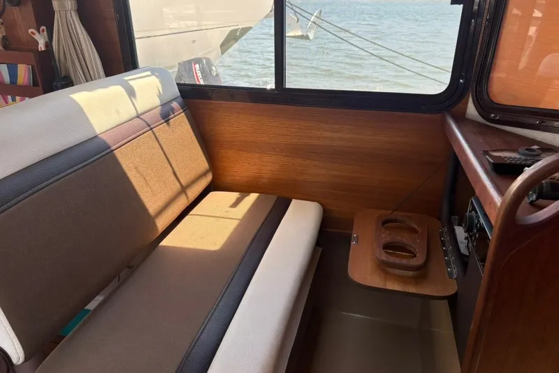 Slide: The Image of Interior of a 2017 Ranger Tugs R-27 boat with seating and wooden accents. - 35