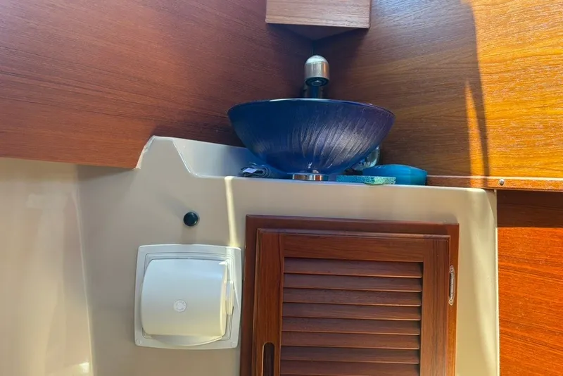 Slide: The Image of Interior of 2017 Ranger Tugs R-27 with wooden cabinetry and blue glass sink. - 55