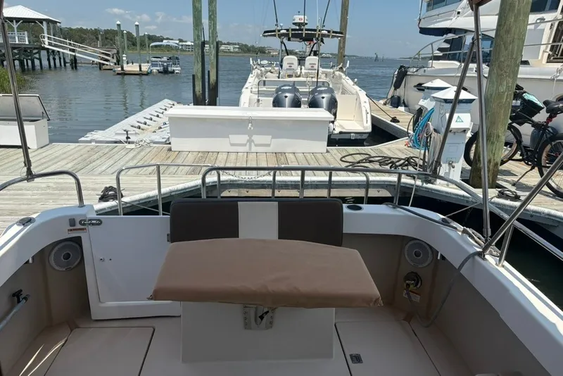 Slide: The Image of 2017 Ranger Tugs R-27 boat docked at a marina with scenic waterfront view. - 13