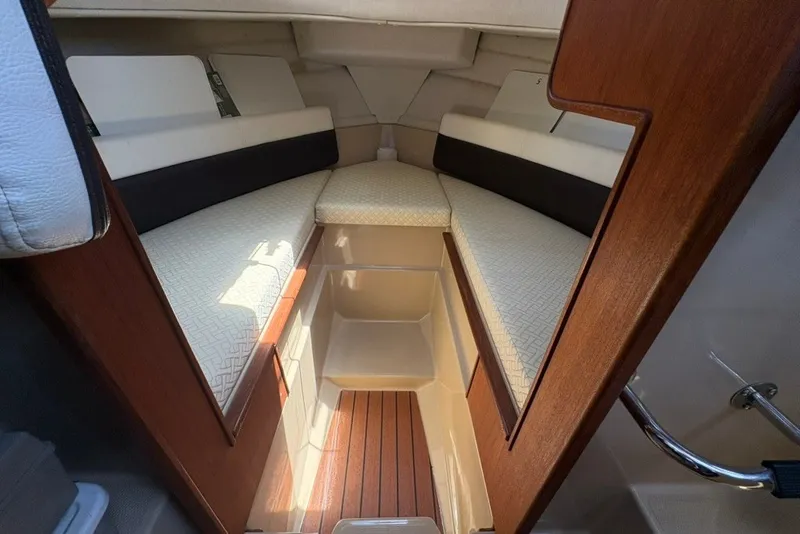 Slide: The Image of 2017 Ranger Tugs R-27 cabin interior with cozy seating and wooden accents. - 42