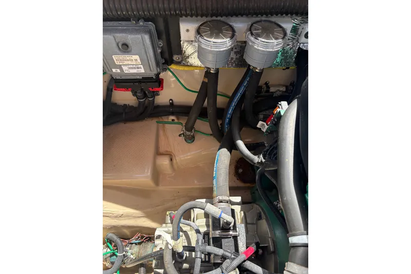 Slide: The Image of Engine compartment of a 2017 Ranger Tugs R-27 with visible wiring and hoses. - 64