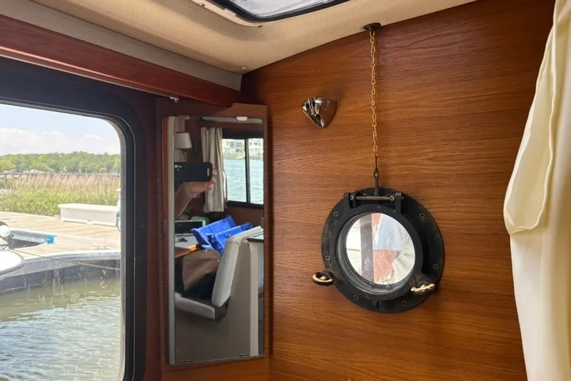 Slide: The Image of Interior of 2017 Ranger Tugs R-27 with porthole and mirror reflecting cabin view. - 54