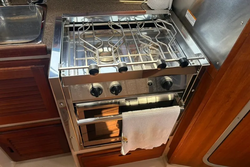 Slide: The Image of Compact kitchen stove and oven in a 2017 Ranger Tugs R-27 boat galley. - 48