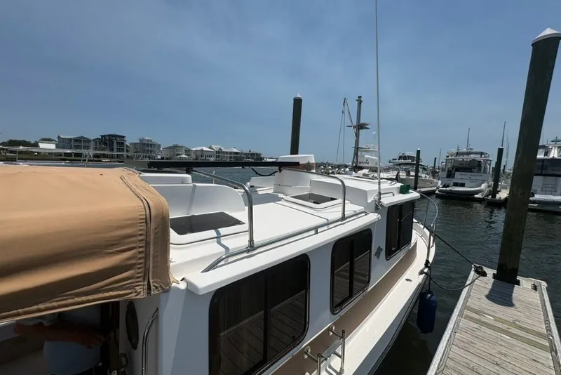 Slide: The Image of 2017 Ranger Tugs R-27 docked at a marina under a clear blue sky. - 19