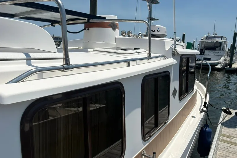 Slide: The Image of 2017 Ranger Tugs R-27 boat docked at a marina, featuring sleek design and windows. - 20