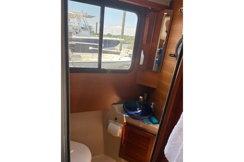 Slide: The Image of Interior of 2017 Ranger Tugs R-27 boat bathroom with window and blue sink. - 52
