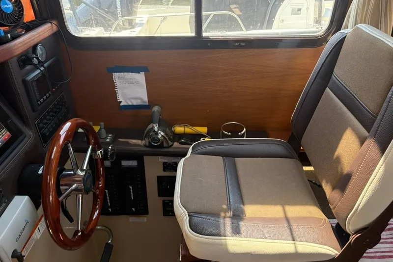 Slide: The Image of 2017 Ranger Tugs R-27 helm with wooden steering wheel and comfortable seating. - 28