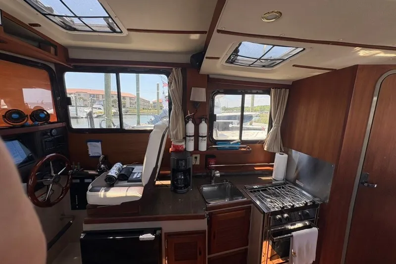 Slide: The Image of Interior of 2017 Ranger Tugs R-27 boat with helm, kitchen, and windows. - 47