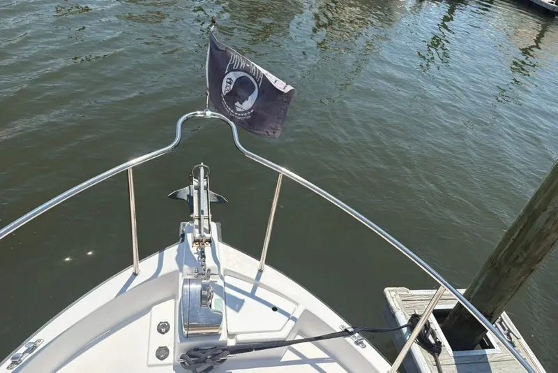 Slide: The Image of Bow view of 2017 Ranger Tugs R-27 with flag and anchor in marina. - 22