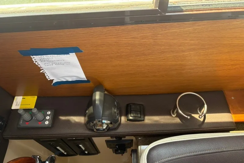 Slide: The Image of 2017 Ranger Tugs R-27 interior dashboard with controls, note, and headset holder. - 29