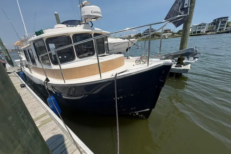 Slide: The Image of 2017 Ranger Tugs R-27 docked at a marina, featuring a sleek design and modern equipment. - 15