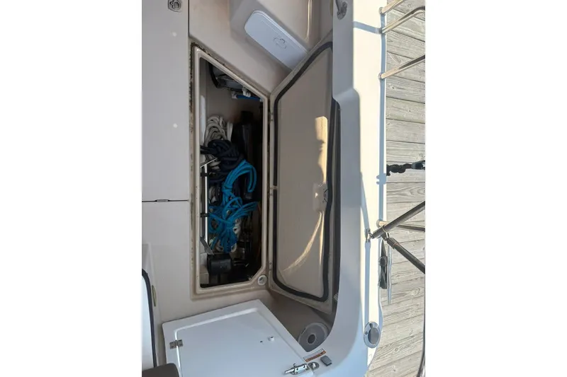 Slide: The Image of Open storage compartment on a 2017 Ranger Tugs R-27 boat, containing ropes and equipment. - 66