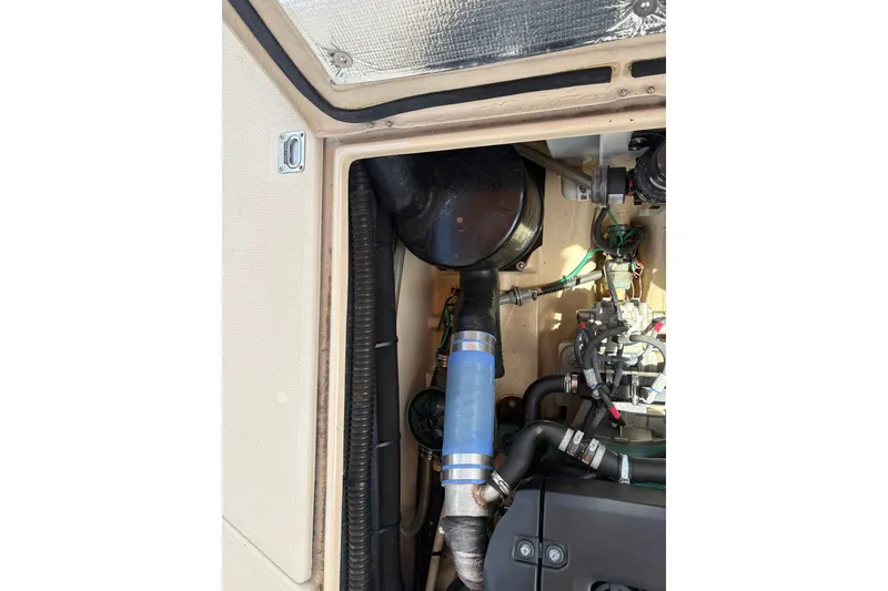 Slide: The Image of Engine compartment of a 2017 Ranger Tugs R-27 boat, showing hoses and components. - 62
