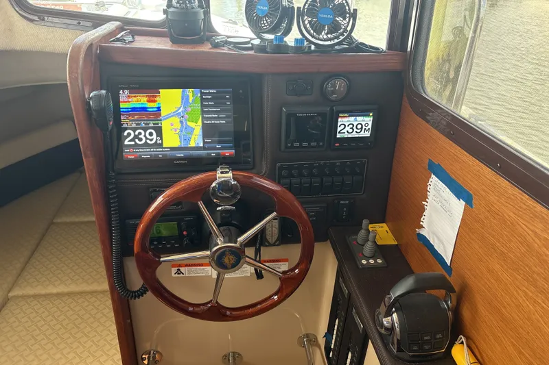Slide: The Image of 2017 Ranger Tugs R-27 helm with navigation screens and controls. - 26