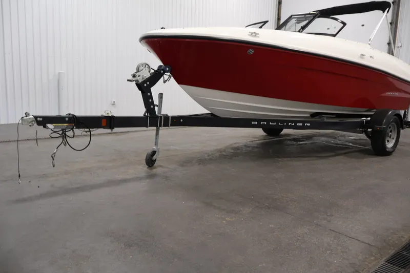 Slide: The Image of 2020 Bayliner VR4 Bowrider I/O on trailer, red and white hull, indoor setting. - 47
