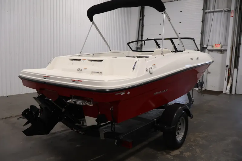 Slide: The Image of 2020 Bayliner VR4 Bowrider I/O boat with red hull in indoor storage. - 5