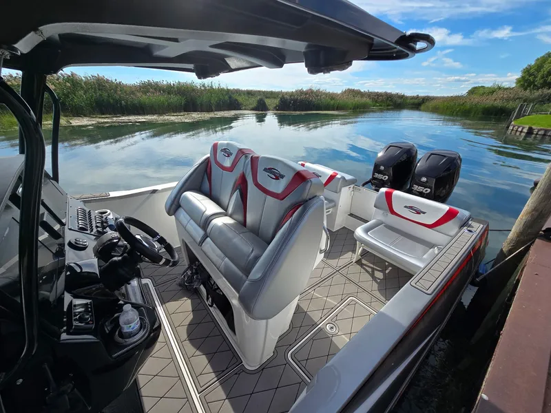 Slide: The Image of A 2017 Sunsation 32 CCX with stylish seating and twin outboard engines, on a calm waterway. - 6