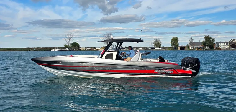 The Image of A 2017 Sunsation 32 CCX boat cruising on calm water. It features a sleek design with red accents. - 0