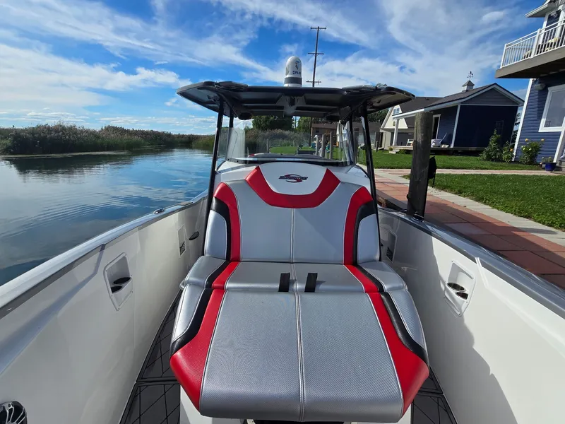 Slide: The Image of A 2017 Sunsation 32 CCX boat with stylish red and gray seating, docked by the water. - 14