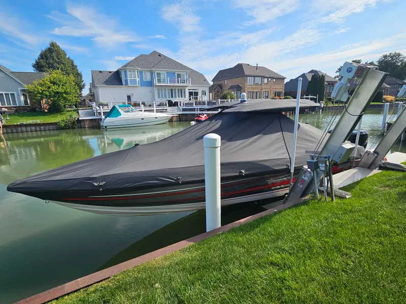 Slide: The Image of A 2017 Sunsation 32 CCX is covered and docked in a peaceful residential canal. - 17