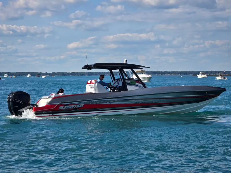 Slide: The Image of A 2017 Sunsation 32 CCX cruising on blue water. It features a sleek design and twin outboard engines. - 1