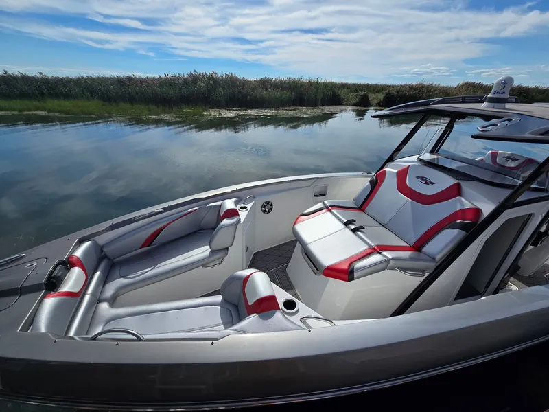 Slide: The Image of The image shows a 2017 Sunsation 32 CCX boat with stylish red and gray seating. - 12