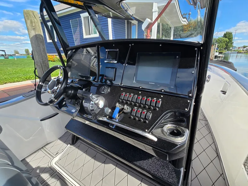 Slide: The Image of The cockpit of a 2017 Sunsation 32 CCX with a modern helm and numerous controls. - 11