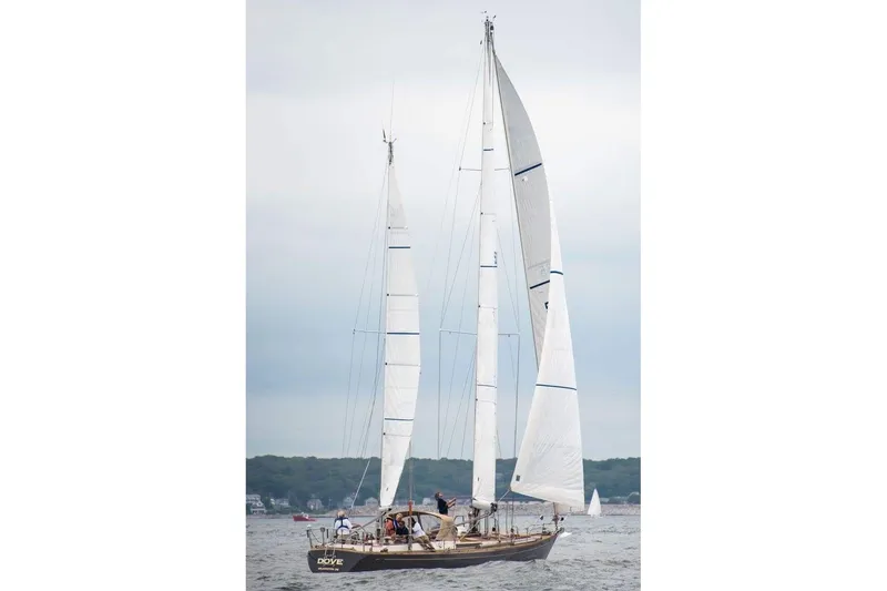 Slide: The Image of 1984 Ta Shing Skye 54 sailboat on open water, full sails, overcast sky. - 7