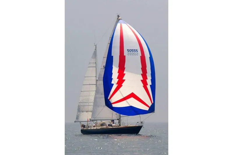 Slide: The Image of 1984 Ta Shing Skye 54 sailboat with colorful spinnaker on open water. - 1