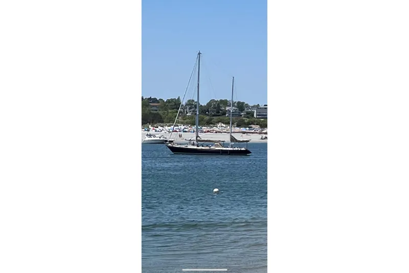 Slide: The Image of 1984 Ta Shing Skye 54 sailboat anchored near a sandy beach. - 3