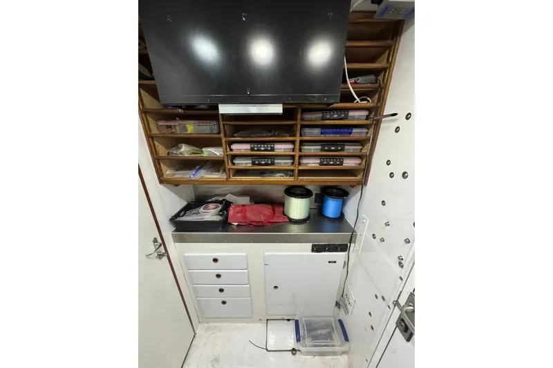 Slide: The Image of Storage area inside a 2001 Southern Composite Sportfish boat, featuring shelves and fishing gear. - 25
